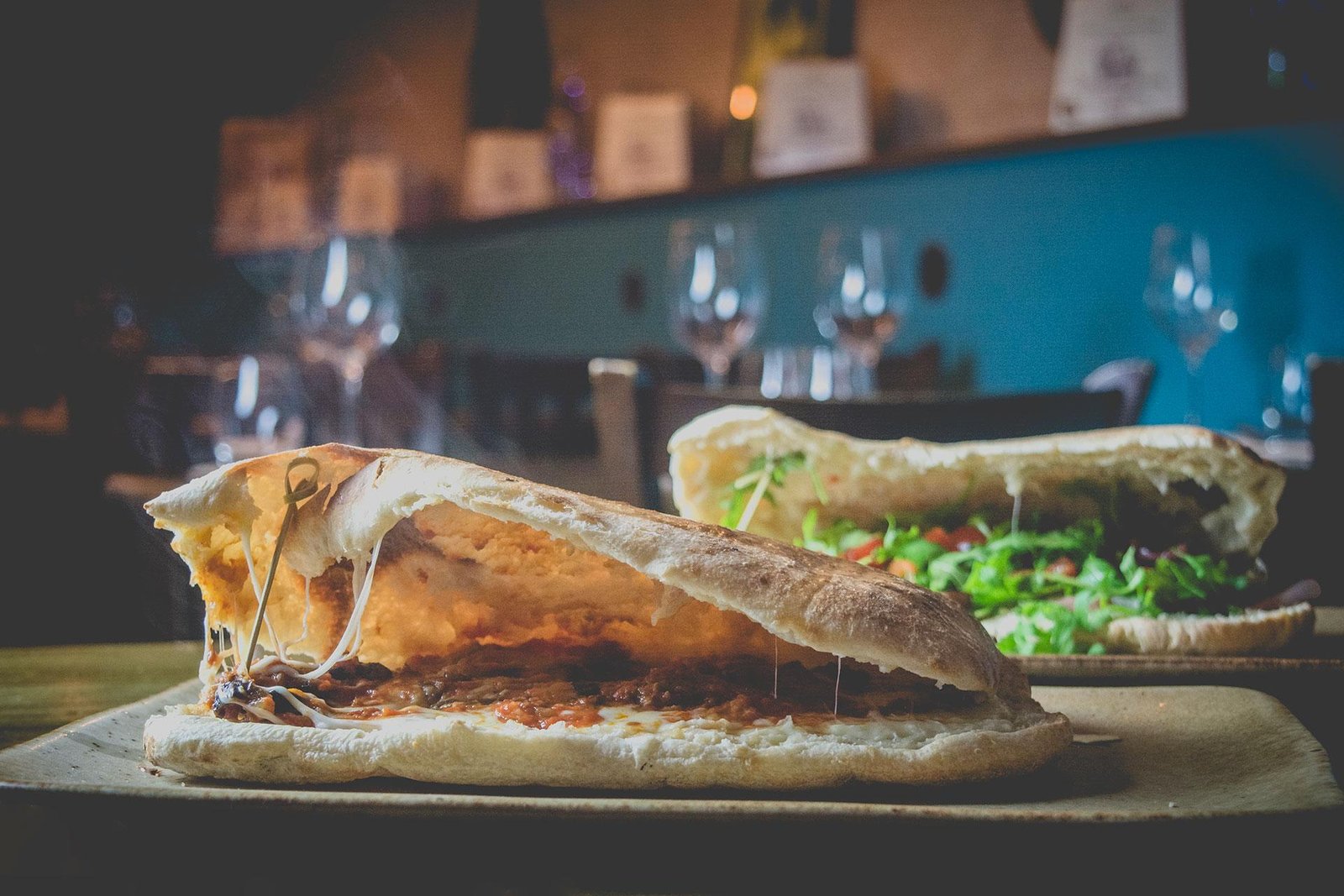 Darkened picture of a vegan flatbread from Spasso propped up with a small wooden stick