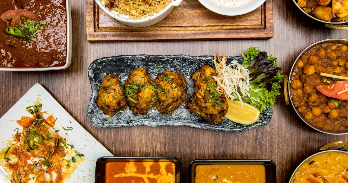 Pictures of a curry and a platter with salad, lemon, and chicken